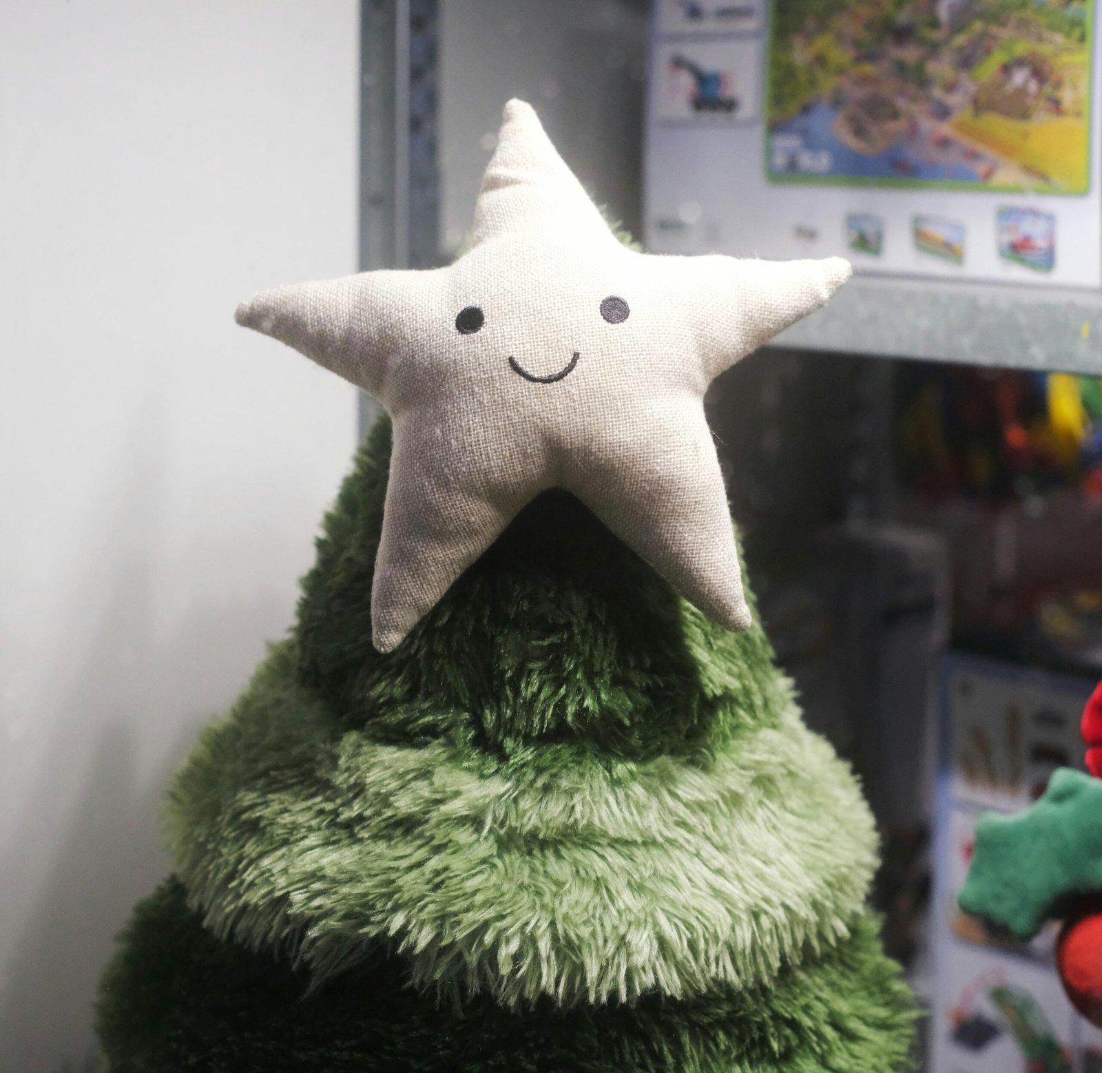 a stuffed star on top of a green christmas tree